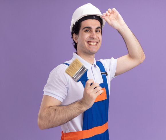 happy-young-builder-man-construction-uniform-safety-helmet-holding-paint-brush-looking-front-smiling-confident-standing-purple-wall (1) https://renfrewpainting.com/wp-content/uploads/2022/04/happy-young-builder-man-construction-uniform-safety-helmet-holding-paint-brush-looking-front-smiling-confident-standing-purple-wall-1.jpg