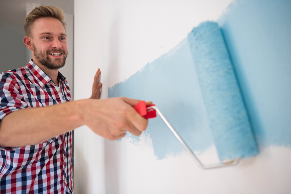 https://renfrewpainting.com/wp-content/uploads/2022/04/young-man-painting-blue-wall.jpg